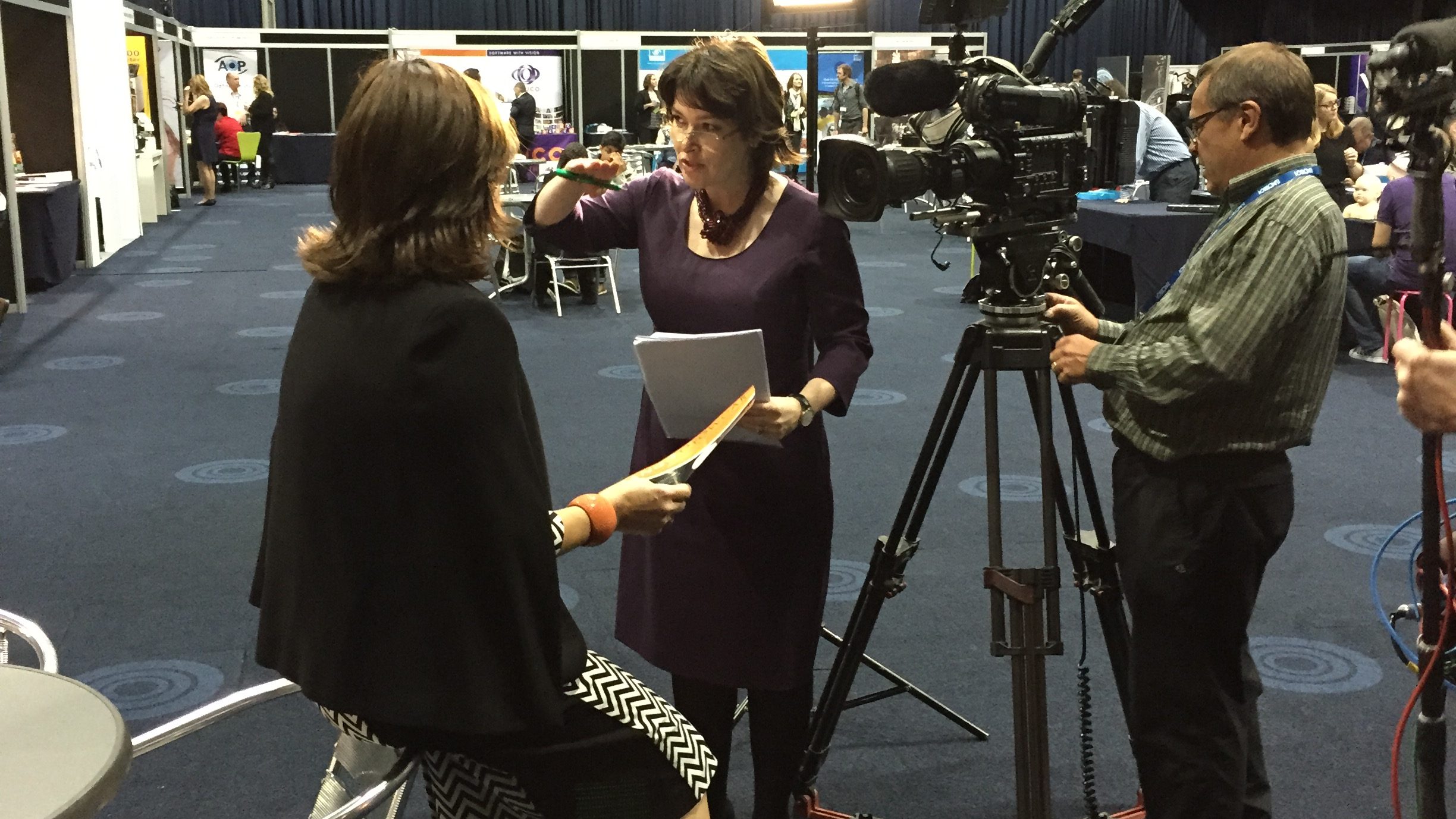 Sarah Lockett with camera crew filming at a conference